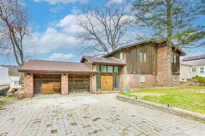 a brick house with a garage and a brick driveway at Waterfront Lake Hopatcong Home with Boat Dock! in Mount Arlington