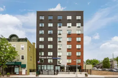 a tall building on a city street with buildings at Days Inn by Wyndham Staten Island in Staten Island