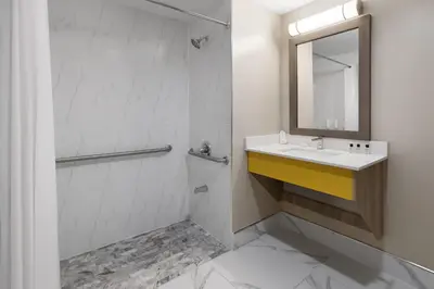 a bathroom with a sink and a mirror at Days Inn by Wyndham Staten Island in Staten Island
