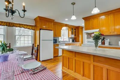 a kitchen with a table and a white refrigerator at Historic Farmhouse in Layton with Deck! in Layton