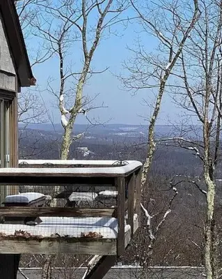 a wooden bench sitting on top of a balcony with a view at Stylish Townhouse Steps to Ski Mtn & Waterpark in Tannersville