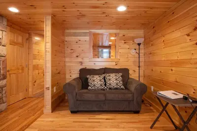 a living room with a couch in a log cabin at Fisher Mountain Retreat in Woodward