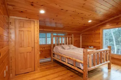 a bedroom with a bed in a log cabin at Fisher Mountain Retreat in Woodward