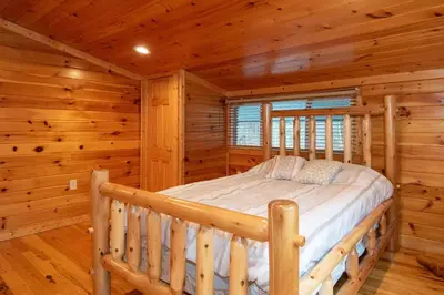 a bedroom with a bed in a log cabin at Fisher Mountain Retreat in Woodward