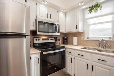 a kitchen with white cabinets and a black stove top oven at Scenic View Lodging in Millerstown