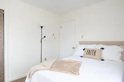 a white bedroom with a bed with white pillows at Scenic View Lodging in Millerstown