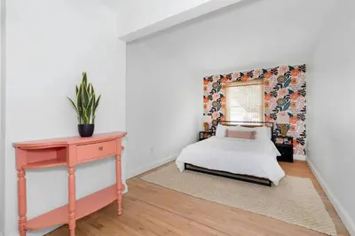a bedroom with a bed and a table and a window at White Clay Creek Cottage in Newark