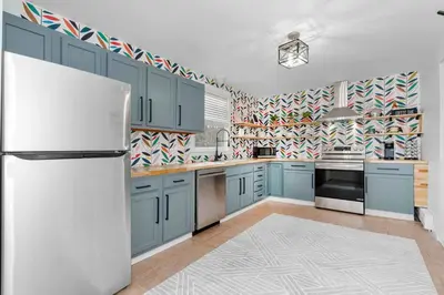 a kitchen with blue cabinets and a white refrigerator at White Clay Creek Cottage in Newark
