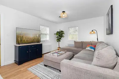 a living room with a couch and a flat screen tv at White Clay Creek Cottage in Newark