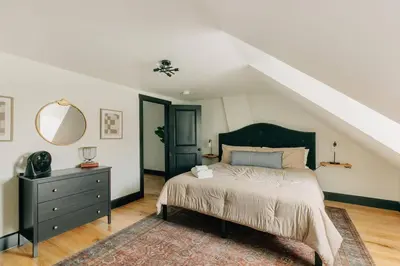 a bedroom with a bed and a dresser with a mirror at Stunning 5 BR -Heart of Downtown in Lancaster