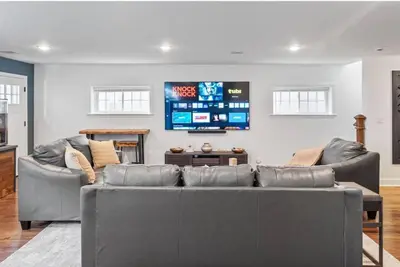 a living room with two couches and a flat screen tv at Dream! in Newark