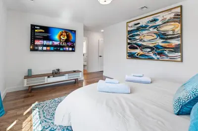 a bedroom with a large white bed and a flat screen tv at Cityscape in Newark