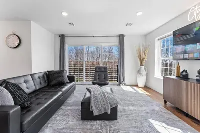 a living room with a black couch and a large window at Cityscape in Newark