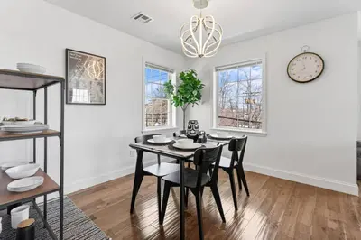a dining room with a table and chairs and a clock at Cityscape in Newark