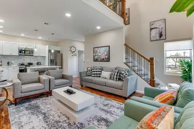 a living room with two couches and a kitchen at Luxe Newark Retreat with Rooftop Deck Pets Welcome! in Newark
