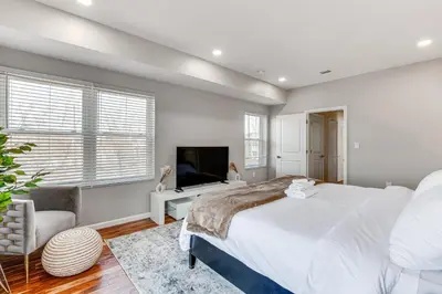 a bedroom with a large bed and a television at Luxe Newark Retreat with Rooftop Deck Pets Welcome! in Newark