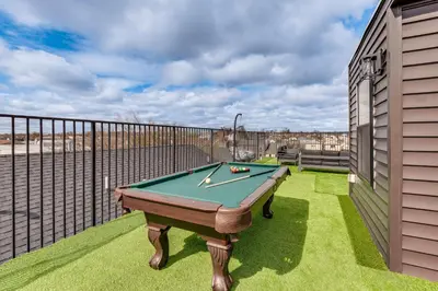 a pool table on the balcony of a house at Luxe Newark Retreat with Rooftop Deck Pets Welcome! in Newark