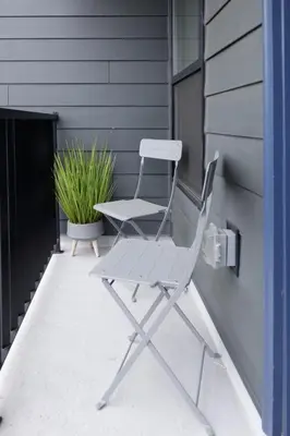 a white chair sitting on a porch with a plant at Comfortable living in Philadelphia