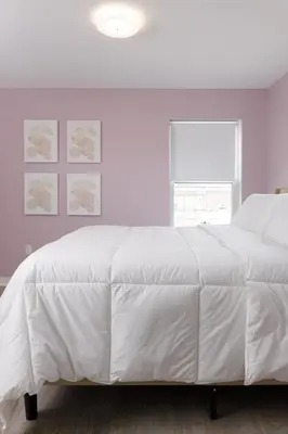 a white bed in a white bedroom with a window at Comfortable living in Philadelphia