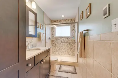a bathroom with a toilet and a sink and a shower at Game Room and Fire Pit Chic Pocono Pines Home! in Pocono Pines