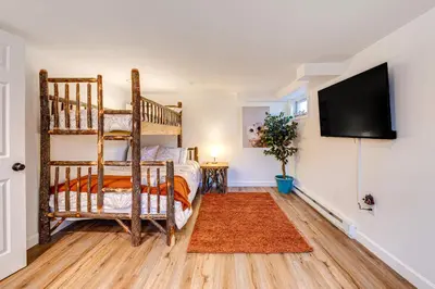 a bedroom with two bunk beds and a flat screen tv at Game Room and Fire Pit Chic Pocono Pines Home! in Pocono Pines