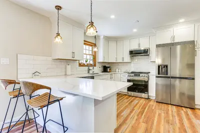 a kitchen with white cabinets and stainless steel appliances at Forest-View Deck and Fire Pit Poconos Escape! in East Stroudsburg