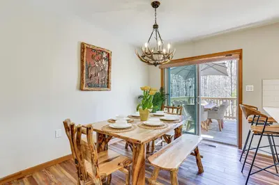a dining room with a wooden table and chairs at Forest-View Deck and Fire Pit Poconos Escape! in East Stroudsburg