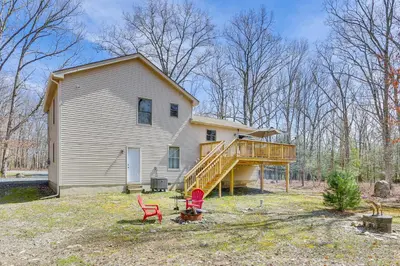 a white house with a porch and a deck at Forest-View Deck and Fire Pit Poconos Escape! in East Stroudsburg