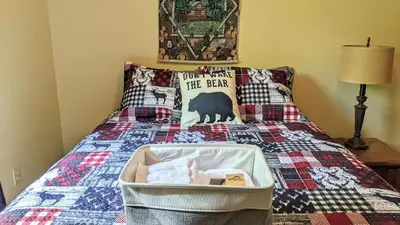 a bed with a blanket with a bear on it at The Bear Foot Lodge by AvantStay Game Room Deck BeachLake Access in Albrightsville