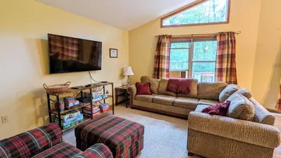 a living room with two couches and a flat screen tv at The Bear Foot Lodge by AvantStay Game Room Deck BeachLake Access in Albrightsville