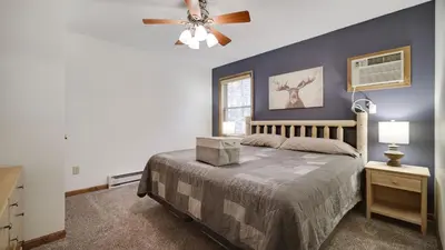 a bedroom with a bed and a ceiling fan at Woodland Oasis by AvantStay Hot Tub Firepit Walk to Lake in Lake Harmony