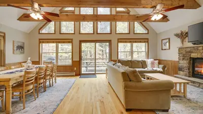 a living room with a couch and a table and a fireplace at Woodland Oasis by AvantStay Hot Tub Firepit Walk to Lake in Lake Harmony