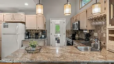 a kitchen with a sink and a refrigerator at The Boulder Inn by AvantStay Indoor Hot Tub Game Room Outdoor Fire Pit in Lake Harmony