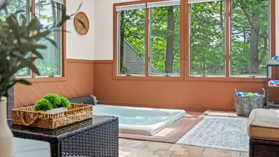 a bath tub in a room with windows at The Boulder Inn by AvantStay Indoor Hot Tub Game Room Outdoor Fire Pit in Lake Harmony