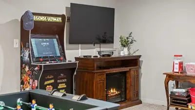 a room with a fireplace with a laptop on top of it at The Boulder Inn by AvantStay Indoor Hot Tub Game Room Outdoor Fire Pit in Lake Harmony