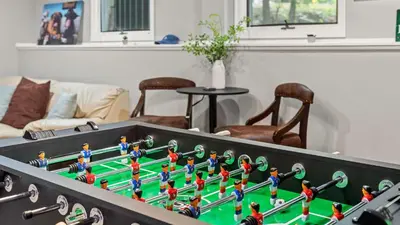 a table with a foosball game in a living room at The Boulder Inn by AvantStay Indoor Hot Tub Game Room Outdoor Fire Pit in Lake Harmony