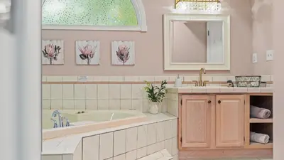 a bathroom with a tub and a sink and a mirror at The Boulder Inn by AvantStay Indoor Hot Tub Game Room Outdoor Fire Pit in Lake Harmony