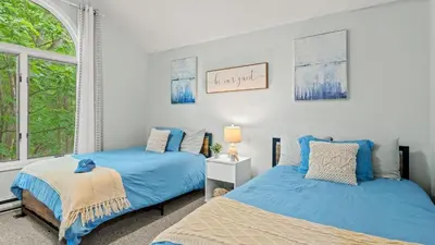 two beds in a bedroom with blue sheets and a window at The Boulder Inn by AvantStay Indoor Hot Tub Game Room Outdoor Fire Pit in Lake Harmony