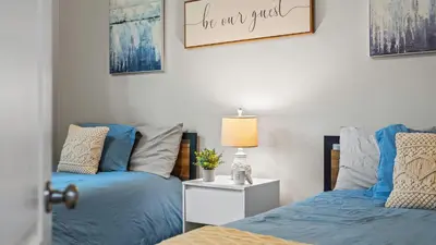 two beds in a bedroom with blue and gray pillows at The Boulder Inn by AvantStay Indoor Hot Tub Game Room Outdoor Fire Pit in Lake Harmony