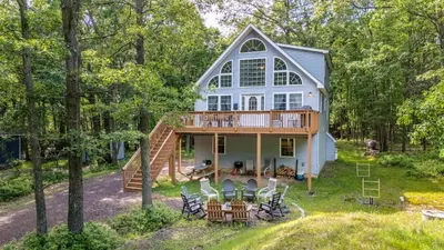 a house with a wrap around porch and a deck at The Nest at Brier Crest by AvantStay Game Room Expansive Deck Fire Pit in Blakeslee
