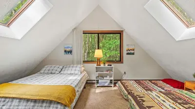 a attic bedroom with two beds and a window at 7mins to Skiing Fire Pit Game Table Lake Access Hygge Home by AvantStay in Blakeslee