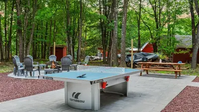 a ping pong table in the middle of a yard at Maple Oasis by AvantStay Newly Built w Hot Tub Game Room Fire Pit in Blakeslee