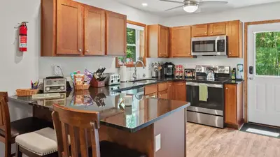 a kitchen with wooden cabinets and a counter top at Maple Oasis by AvantStay Newly Built w Hot Tub Game Room Fire Pit in Blakeslee