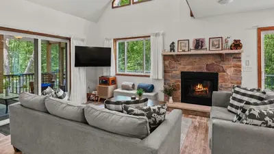 a living room with a couch and a fireplace at Maple Oasis by AvantStay Newly Built w Hot Tub Game Room Fire Pit in Blakeslee