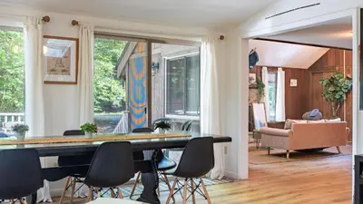 a living room with a dining room table and chairs at Lakeshore Oasis by AvantStay Private Beach Views Hot Tub Volleyball in Blakeslee