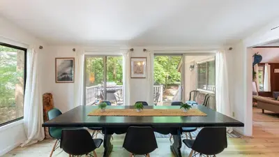 a living room with a black table and chairs at Lakeshore Oasis by AvantStay Private Beach Views Hot Tub Volleyball in Blakeslee