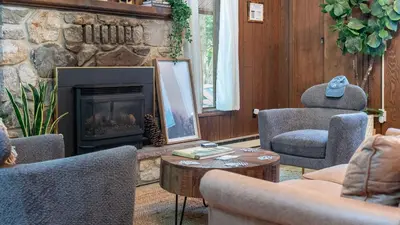 a living room with couches and a fireplace at Lakeshore Oasis by AvantStay Private Beach Views Hot Tub Volleyball in Blakeslee