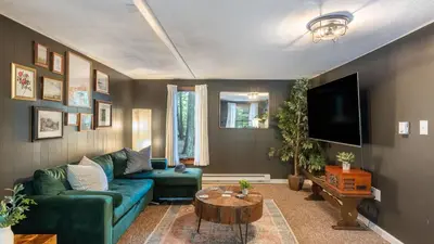 a living room with a green couch and a tv at Lakeshore Oasis by AvantStay Private Beach Views Hot Tub Volleyball in Blakeslee