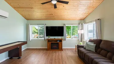 a living room with a couch and a flat screen tv at The Lake Life by AvantStay Lakefront View Hot Tub in Arrowhead Lake