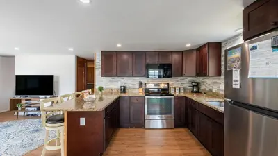 a kitchen with wooden cabinets and stainless steel appliances at The Lake Life by AvantStay Lakefront View Hot Tub in Arrowhead Lake